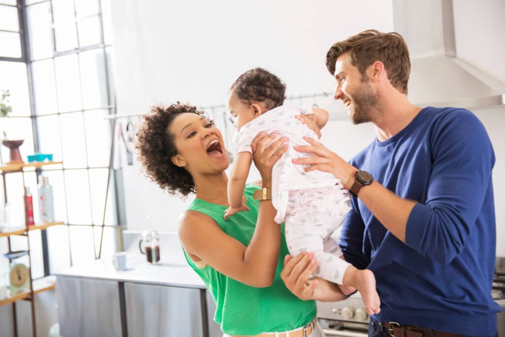 happy-parents-holding-up-a-baby