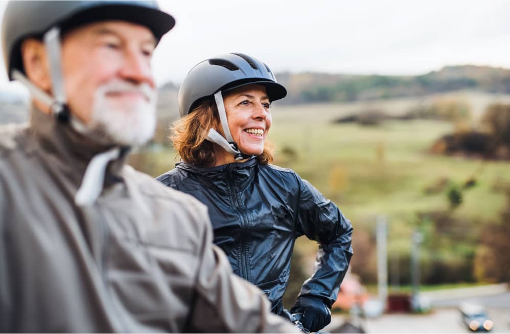 older-couple-enjoying-stop-on-an-outdoor-bike-ride-on-a-rainy-day